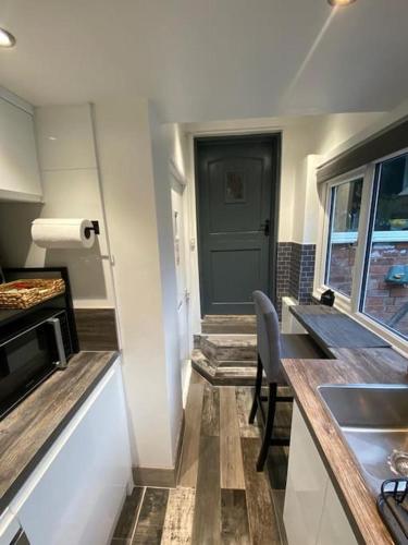 a small kitchen with a sink and a door at Studio 49 home from home in Birmingham