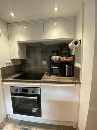 a kitchen with a stove and a microwave at Studio 49 home from home in Birmingham