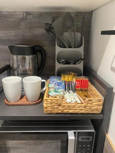 a microwave with two cups and a tray on top of it at Studio 49 home from home in Birmingham