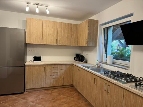 a kitchen with wooden cabinets and a stainless steel refrigerator at Dom przy Rezerwacie in Trzciel