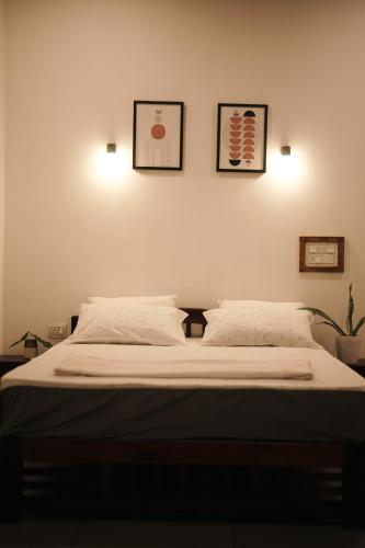 a bedroom with a bed with three pictures on the wall at Marari Bobans villa in Mararikulam