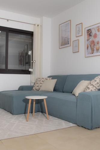 a blue couch in a living room with a table at Modern Beach Apartment - La Maca in Tamariu