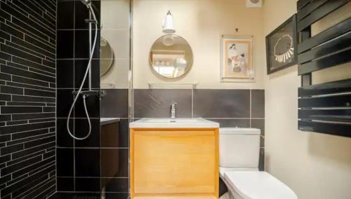 une salle de bain avec un lavabo et des toilettes dans l'établissement Maisonette indépendante tout confort et son jardin, à Paris