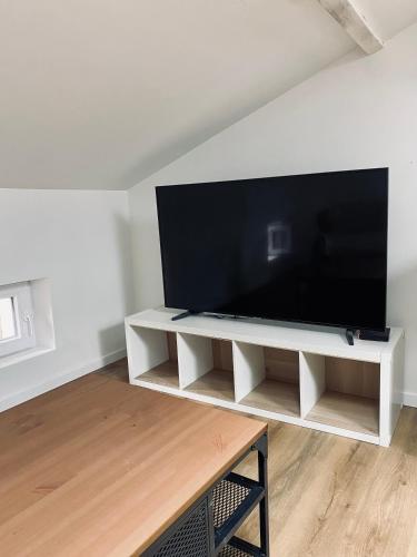 アルビにあるL'échappée belle d'Albiの白いエンターテイメントセンターに座って大画面薄型テレビを楽しめます。