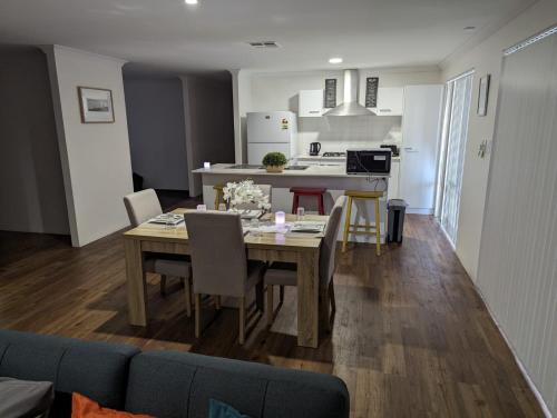 a dining room and kitchen with a table and chairs at 4 Bedroom Wandina Home - 5 TVs & Close to Shopping Centre in Geraldton