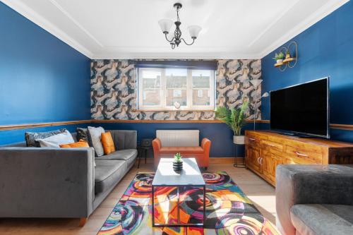a living room with a couch and a tv at Detached House in Ashford with Free Parking and Hot Tub - Sleeps 10 in Ashford