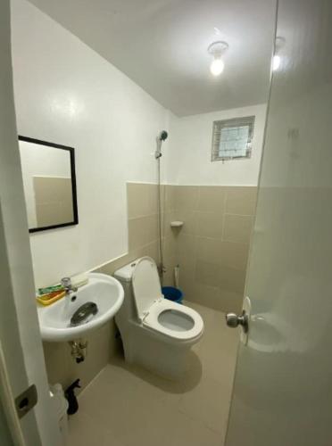 a bathroom with a toilet and a sink at JM Transient House in Butuan