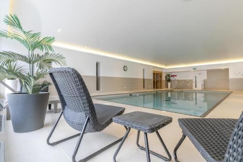 a house with a pool and two chairs and a plant at 7 Middlecombe - Luxury Apartment at Byron Woolacombe, only 4 minute walk to Woolacombe Beach! in Woolacombe