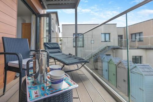 a balcony with a table and chairs on a balcony at 7 Middlecombe - Luxury Apartment at Byron Woolacombe, only 4 minute walk to Woolacombe Beach! in Woolacombe