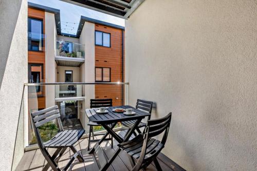 a patio with a table and chairs on a balcony at Byron - Luxury Self-Catering Coastal Apartment at the Heart of Woolacombe with Heated Indoor Pool & Gym - 4 Minutes Walk to Beach! 6 Middlecombe in Woolacombe