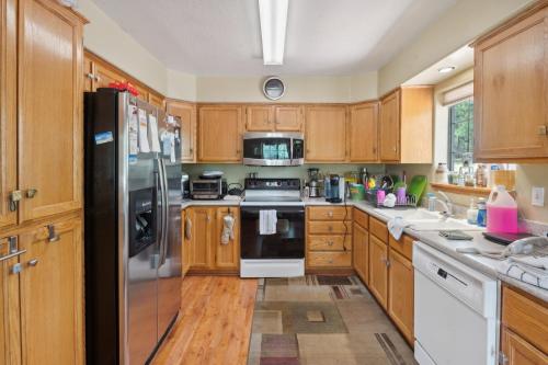 a kitchen with wooden cabinets and a stainless steel refrigerator at Secluded Mountain Cabin with Forest Views cabin in Happy Jack