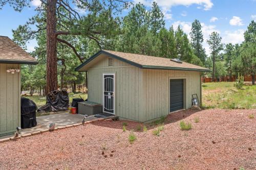 a small green shed in a yard at Secluded Mountain Cabin with Forest Views cabin in Happy Jack