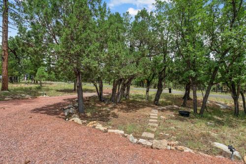 a path in a park with trees and rocks at Secluded Mountain Cabin with Forest Views cabin in Happy Jack