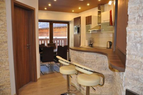 a kitchen and dining room with a bar with stools at Apartmán Chopok Juh Eva in Tale