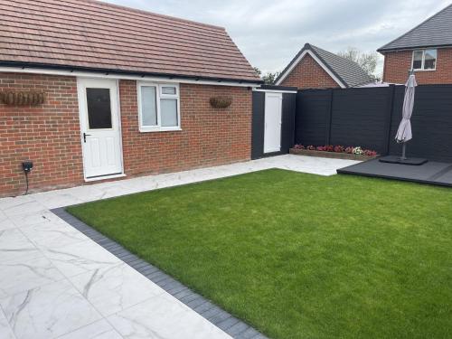 a garden with a fence and a lawn at Modern-luxury 1bedroom-EnsuiteBathroom-Garden-Wifi in Basildon