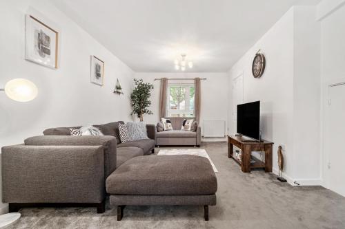 a living room with a couch and a tv at Ashford Home off M20 with 2x Private Parking - Long Stays in Kent