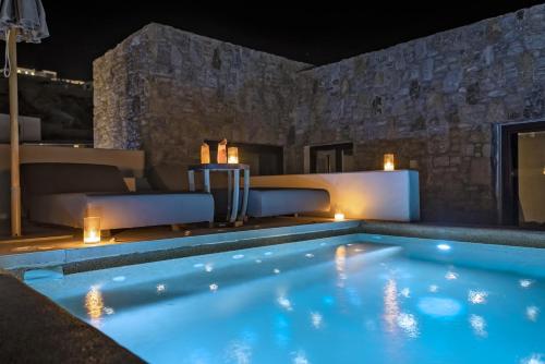 a swimming pool at night with lights in a house at Aeonic Suites and Spa in Mýkonos City