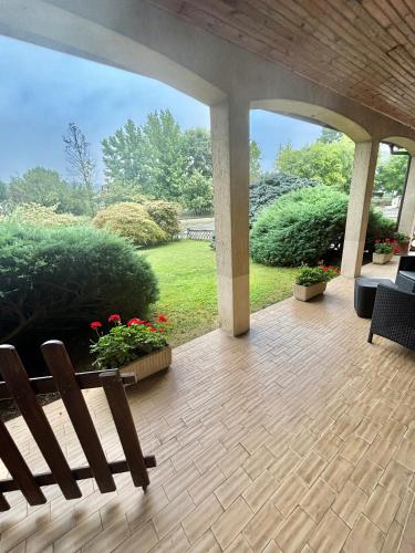 an outdoor patio with a bench and flowers at Casa tra le vigne in Mombercelli