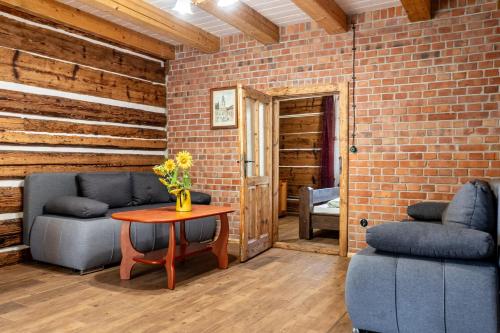 a room with a table and two chairs and a brick wall at Orzechowa Ostoja noclegi Energylandia in Bachowice