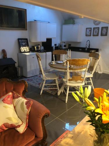 a living room with a table and chairs and a kitchen at lavender house in Ironbridge