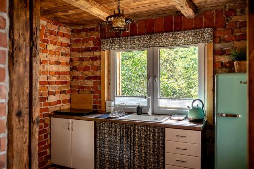 a kitchen with a sink and a brick wall at Orzechowa Ostoja noclegi Energylandia in Bachowice