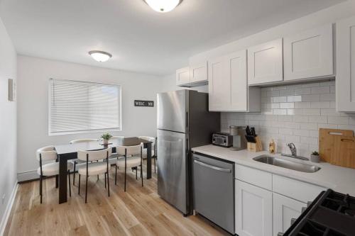 a kitchen with a refrigerator and a table with chairs at Cozy 2BR Near O Hare Free WiFi and Parking in Des Plaines