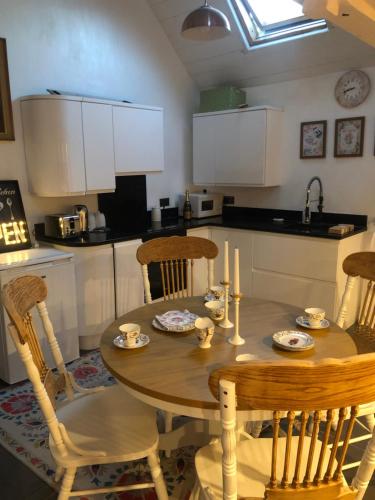 a kitchen with a wooden table with chairs and a sink at lavender house in Ironbridge