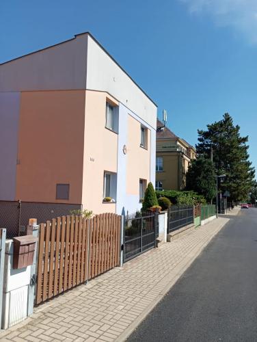 a white house with a fence next to a street at Apartmán u Váňů in Ústí nad Labem