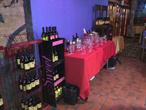 a table with wine bottles and glasses on it at Tradewinds Airport Hotel in Inglewood