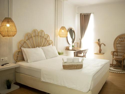 a bedroom with a large white bed with a basket on it at Villa Tjokro in Yogyakarta