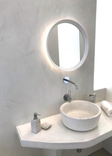 a bathroom with a white sink and a mirror at Komos Beach Estate in Kalamaki