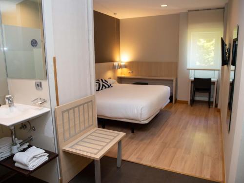a hotel room with a bed and a sink at Hotel Restaurante Cadosa in Soria