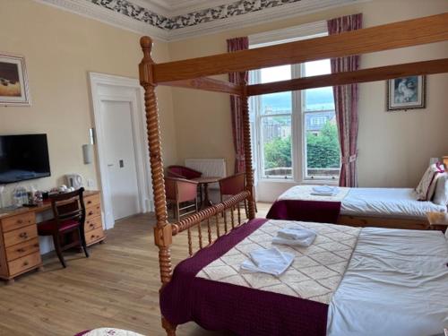 a bedroom with two beds and a large window at Cumberland Hotel in Edinburgh