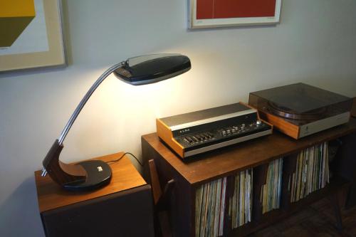 a lamp sitting on a table next to a shelf with dvds at VIC Aveiro Arts House in Aveiro