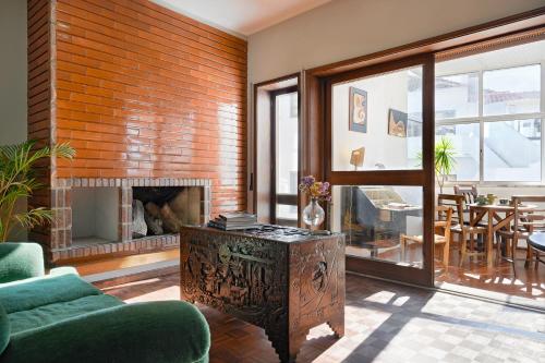 a living room with a brick wall and a fireplace at VIC Aveiro Arts House in Aveiro