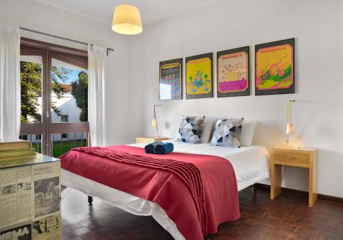 a bedroom with a large bed with a red blanket at VIC Aveiro Arts House in Aveiro