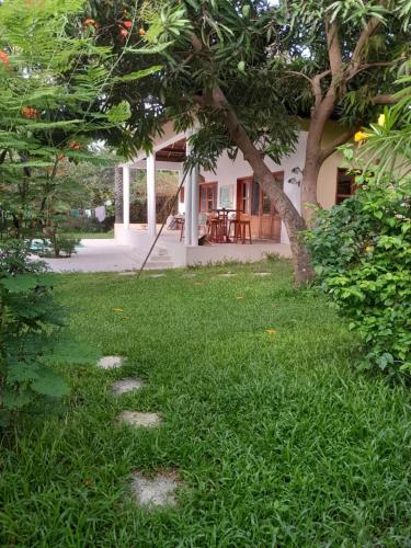 a yard with stones in the grass in front of a house at Villa Saraba in Mossor