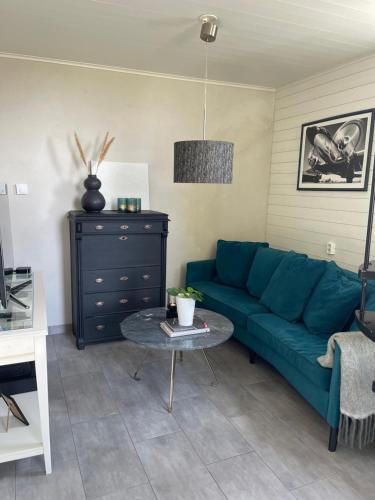 a living room with a blue couch and a table at Utterbyn/Sirsjön in Persby