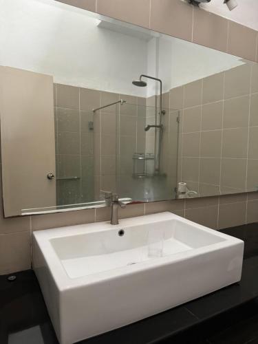 a bathroom with a white sink and a mirror at HmHome-Four in Rumah Ide