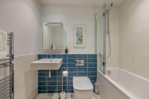 Un baño con inodoro, lavabo y bañera. en 12 Putsborough - Luxury Apartment at Byron Woolacombe, only 4 minute walk to Woolacombe Beach!, en Woolacombe