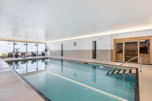 a swimming pool with blue water in a building at 12 Putsborough - Luxury Apartment at Byron Woolacombe, only 4 minute walk to Woolacombe Beach! in Woolacombe