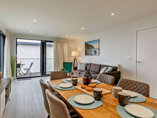 a dining room and living room with a table and chairs at 12 Putsborough - Luxury Apartment at Byron Woolacombe, only 4 minute walk to Woolacombe Beach! in Woolacombe