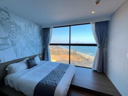 a bedroom with a bed and a large window at APEC Mandala - căn hộ in Ấp Thiẹn Ái
