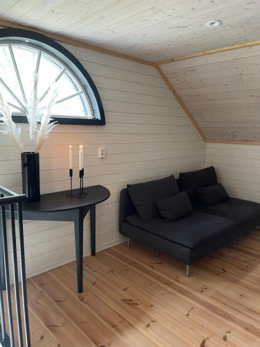 a couch in a room with a table and a window at Utterbyn/Sirsjön in Persby