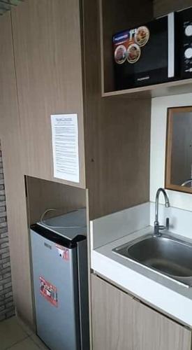 a small kitchen with a sink and a refrigerator at Urban Deca Tower OYO in Manila