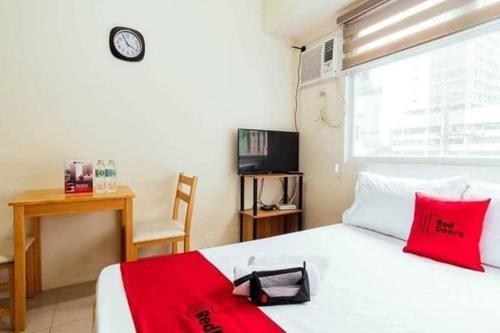 a bedroom with a bed and a desk and a clock at Urban Deca Tower OYO in Manila