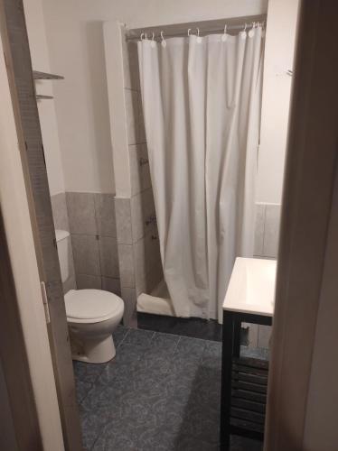 a bathroom with a toilet and a shower curtain at Hotel Santa Eulalia II in Miramar
