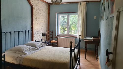 a bedroom with a bed and a window and a desk at Le Pressoir de Marsac in Marsac