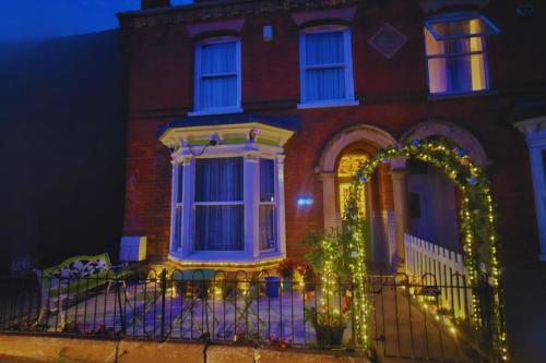 a house with a fence and an arch with christmas lights at Modern En-suite Doubles in Boston Town Spacious & Contemporary Rooms in Boston