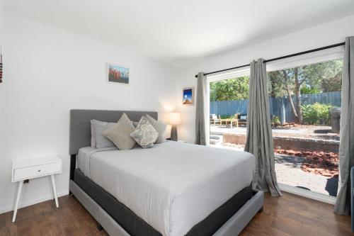 a bedroom with a bed and a large window at Amethyst Retreat. Back Yard with Hot Tub & Views! in Sedona